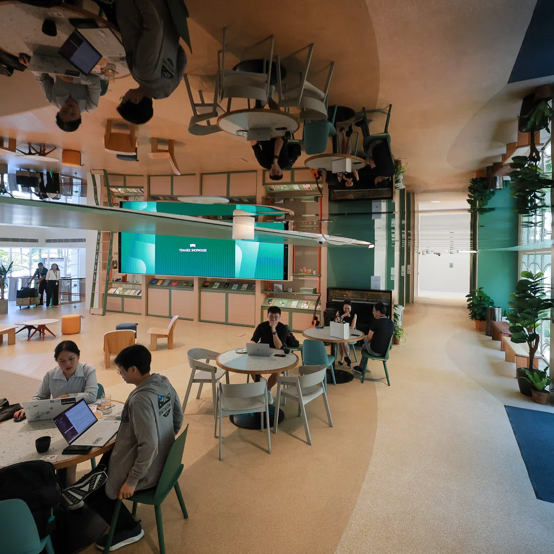 A walkway with a mirrored ceiling connects the interior spaces of the newly renovated Temasek Shophouse.