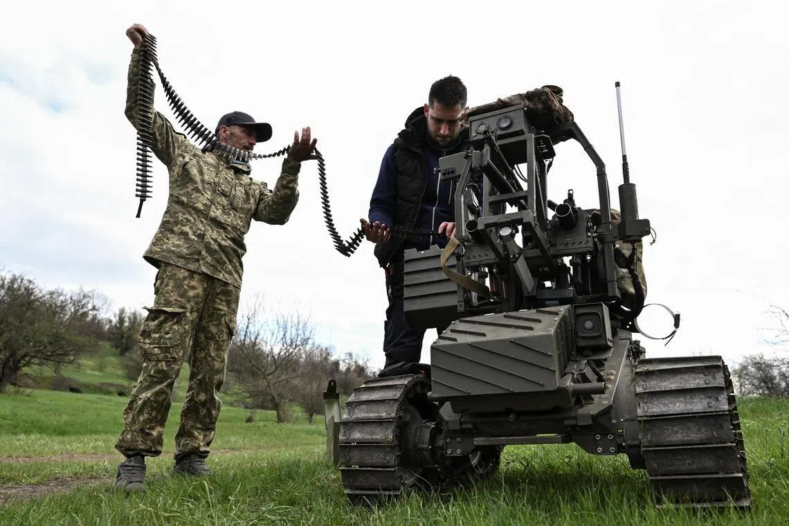 Ukrainian servicemen loading ammunition into an unmanned ground vehicle before testing it, on April 10.