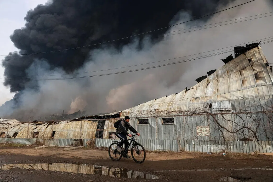 A resident rides a bicycle near the site of a Russian drone strike, amid Russia's attack on Ukraine, in Odesa, Ukraine March 11, 2025. REUTERS/Nina Liashonok