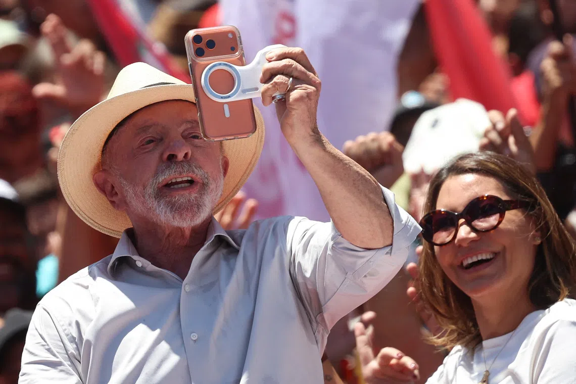 Brazilian President Luiz Inacio Lula da Silva, the Workers' Party (PT) candidate for reelection, holds his wife Rosangela \"Janja\" da Silva's phone at a campaign rally, ahead of the presidential runoff election, in Brasilia, Brazil, October 9, 2026. REUTERS/Adriano Machado