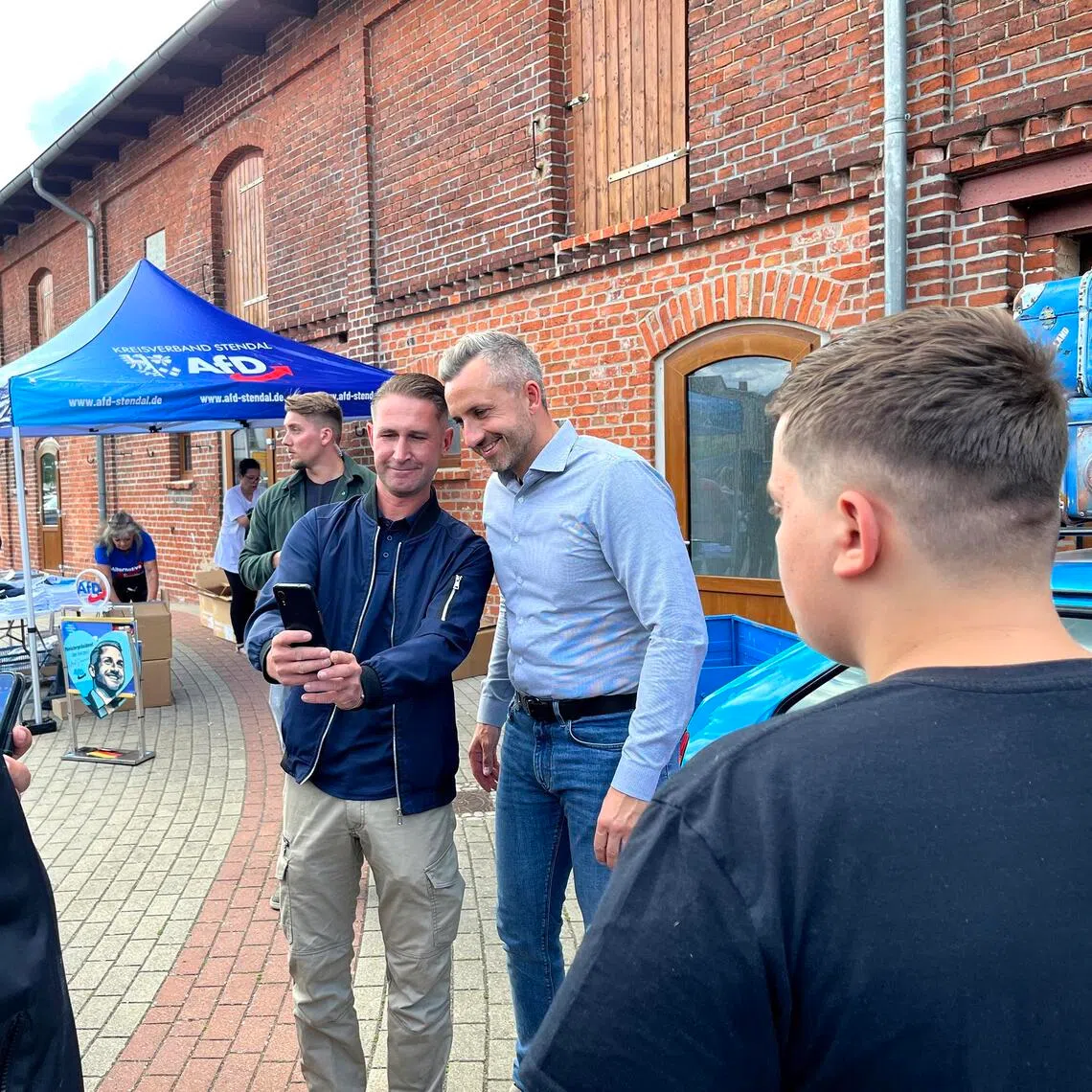 AfD politician Ulrich Siegmund (centre right) taking selfies with supporters at a campaign event on July 21.