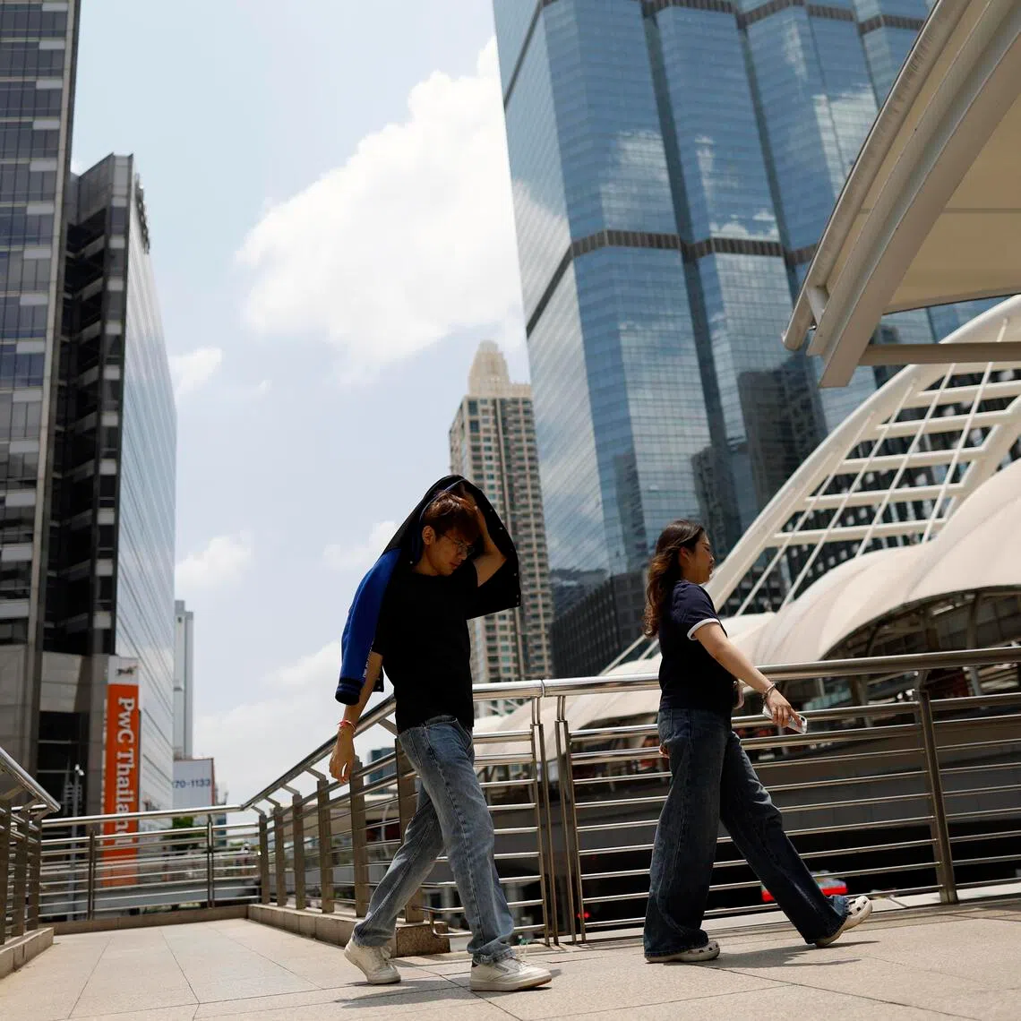 A Thai man protects himself from the sun during hot weather in Bangkok, Thailand on March 30, 2026.