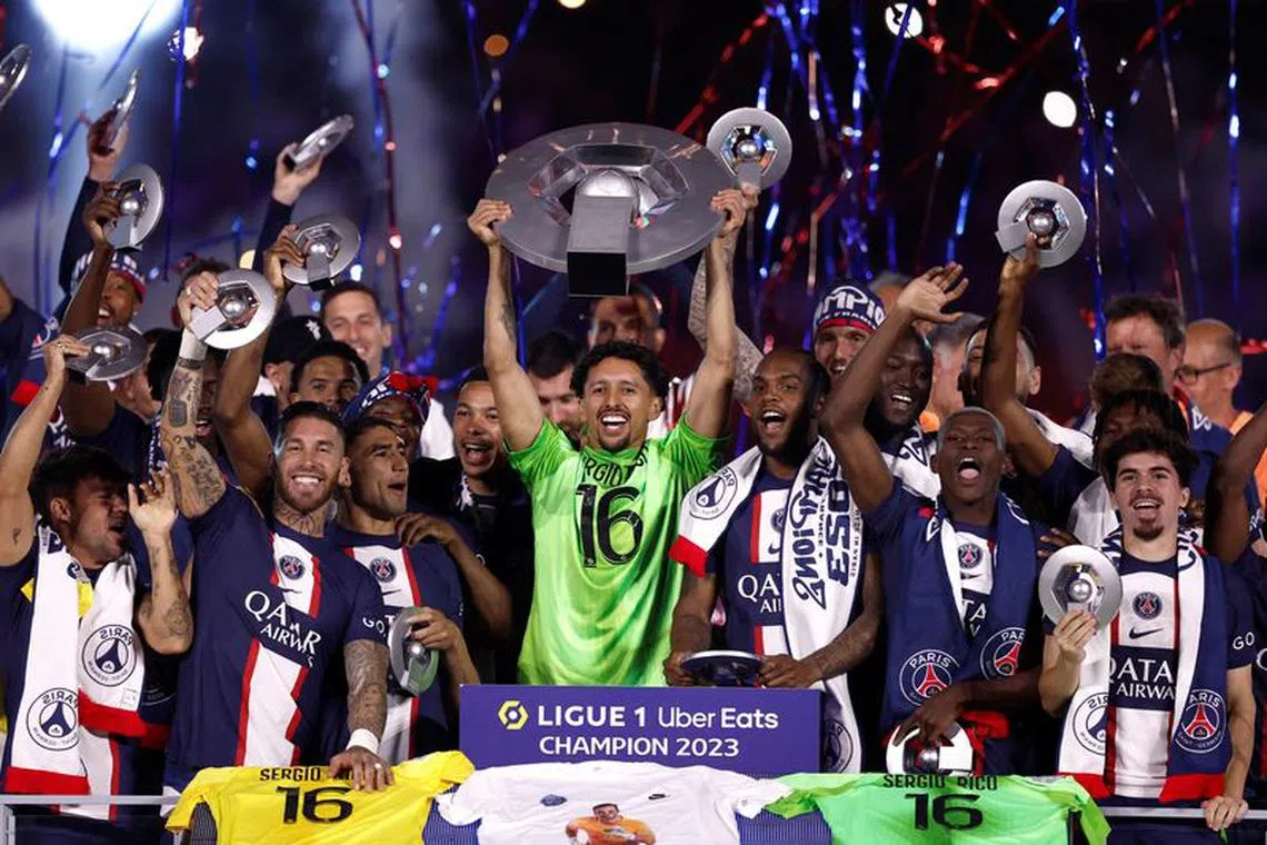 FILE PHOTO: Soccer Football - Ligue 1 - Paris St Germain v Clermont - Parc de Princes, Paris, France - June 3, 2023  Paris St Germain's Marquinhos and team mates celebrate winning the Ligue 1 with the trophy REUTERS/Benoit Tessier