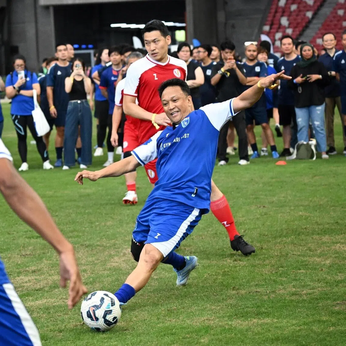 Team Singa Legend?s Fandi Ahmad (centre) passing the ball to his teammate Fazrul Nawaz (left) as Team Parliamentarian?s Acting MCCY Minister David Neo (background) defends during the Football With A Heart 2026 football match on April 25, 2026.