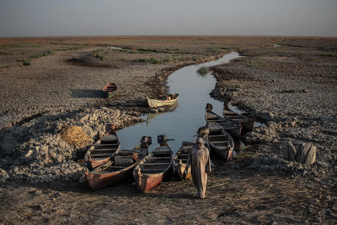 FILE — Mashoofs, a type of boat used by residents of Mesopotamia’s marshes, parked at the edge of a shrinking waterway in Chibayish, Iraq, Sept. 29, 2022. Syria, Iraq and Iran were parched by high temperatures that would have been ‘virtually impossible’ without the effects of global warming, scientists said. (Bryan Denton/The New York Times)