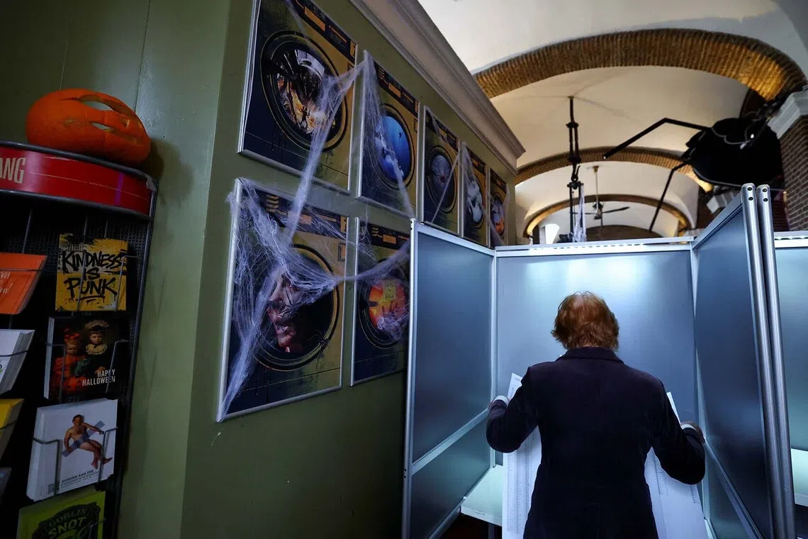 A person voting in a cafe, De Boterwaag, that is decorated for Halloween, during the Dutch parliamentary election, in The Hague, Netherlands, Oct 29, 2025. 