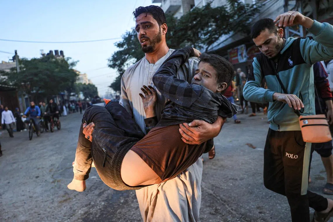 Palestinians help a boy injured in an Israeli strike in Rafah.