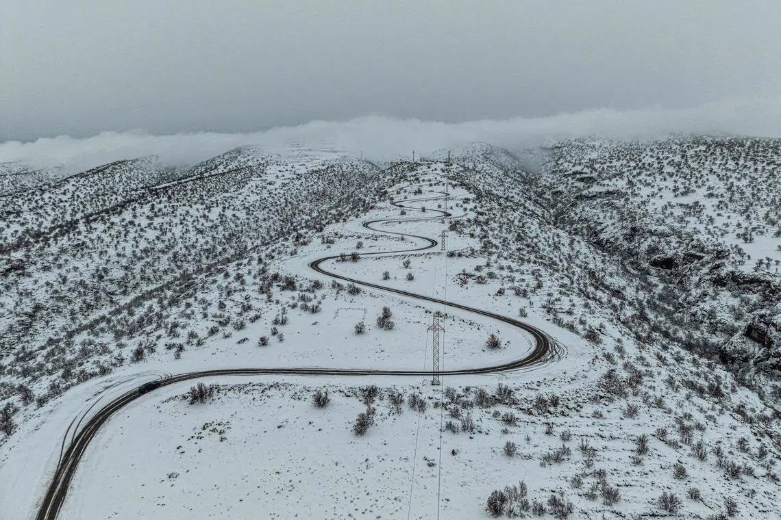 A car along the the snow-covered Mount Sinjar, a 100-kilometre-long mountain range in northwestern Iraq near the Syrian border, on Jan 18, 2026. 