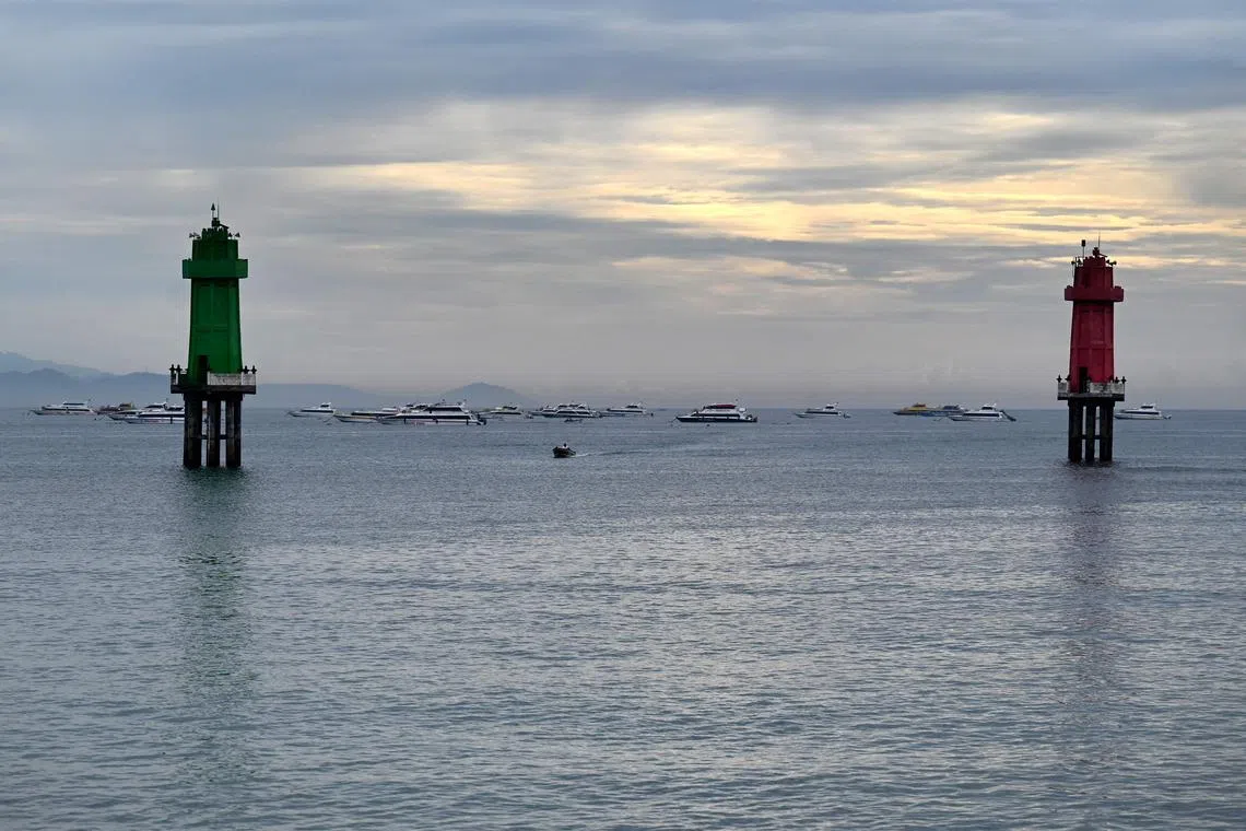 Passenger ferries queue near a pier to transport tourists from Sanur to Nusa Penida, a small island east of Bali. 