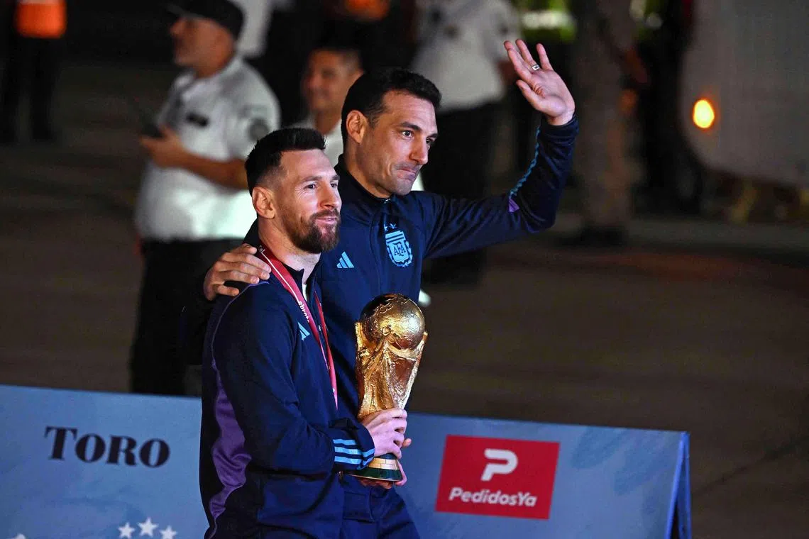 Argentina's captain Lionel Messi holding the World Cup alongside coach Lionel Scaloni upon arrival at Ezeiza International Airport on Dec 20, 2022 after the team won the Qatar 2022 tournament.