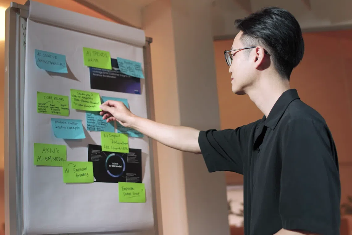 akin founder arvin tang looking at a whiteboard filled with post-it notes, brainstorming on impactful brand campaigns for the singapore-based marketing and ai consultancy