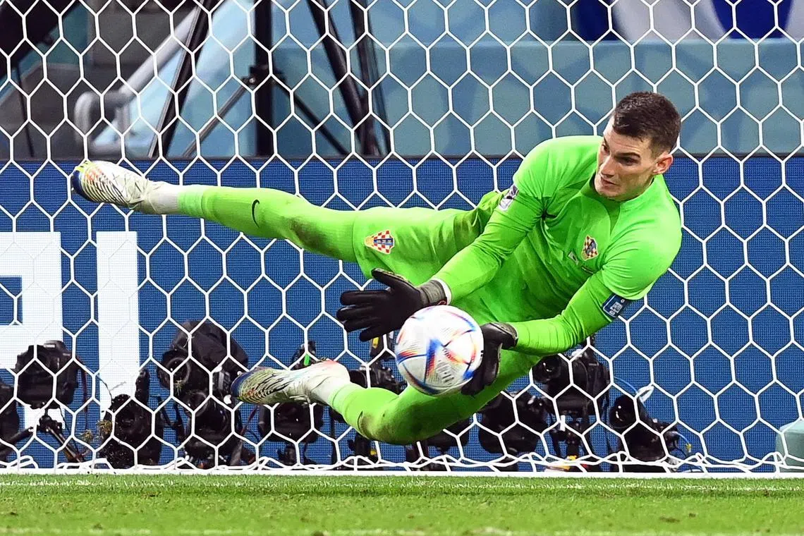 Croatia's goalkeeper Dominik Livakovic saves the penalty from Japan's Takumi Minamino of Japan.
