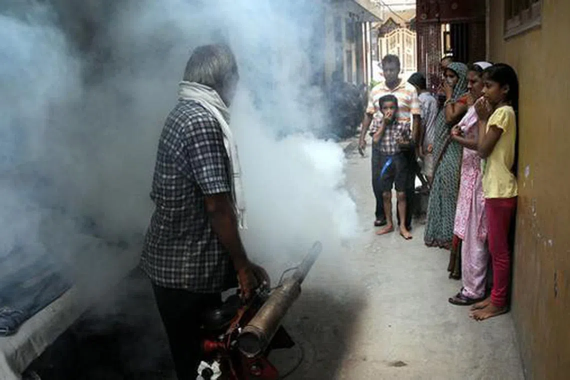 A sanitation worker fumigates a residential area as part of an anti-dengue fumigation drive in New Delhi in this file photo. PHOTO: EPA/STR