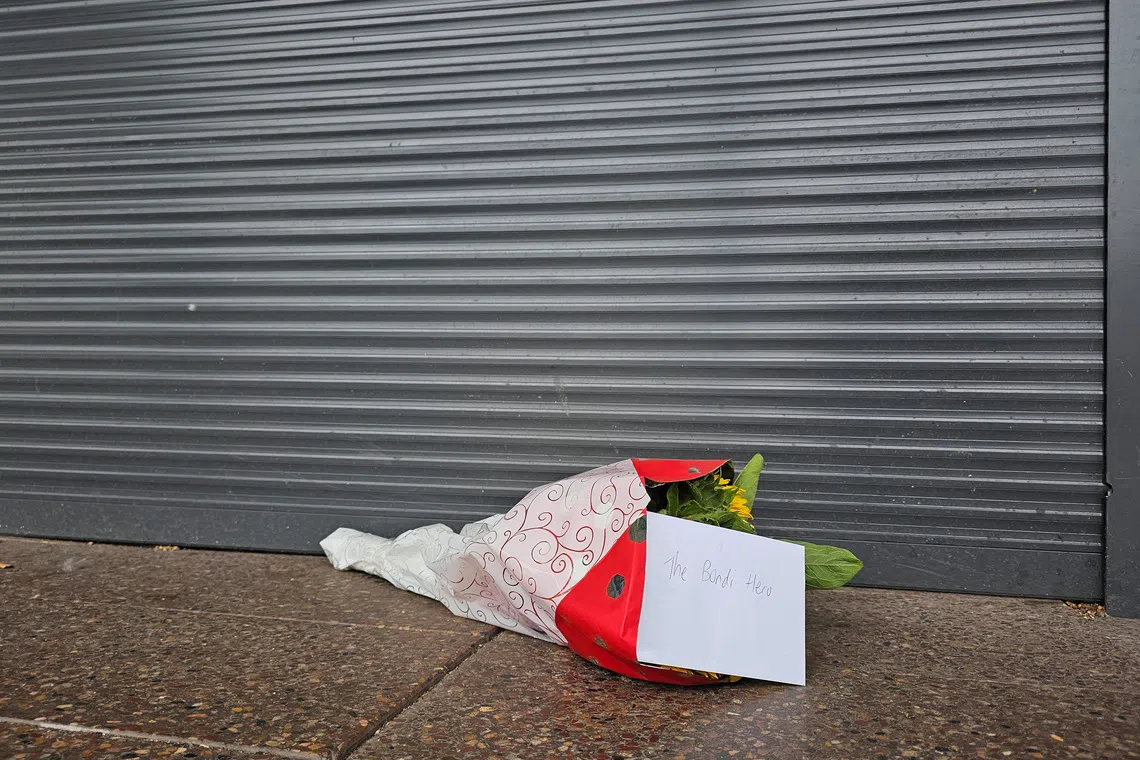 Flowers with a note that read \"The Bondi Hero\" are left outside tobacco shop owned by Ahmed al Ahmed, the bystander who is hailed as the \"Bondi hero\" after he charged at one of the gunmen and seized his rifle during the deadly shooting at Bondi Beach, in Sydney, Australia, December 16, 2025. Reuters/Cordelia Hsu