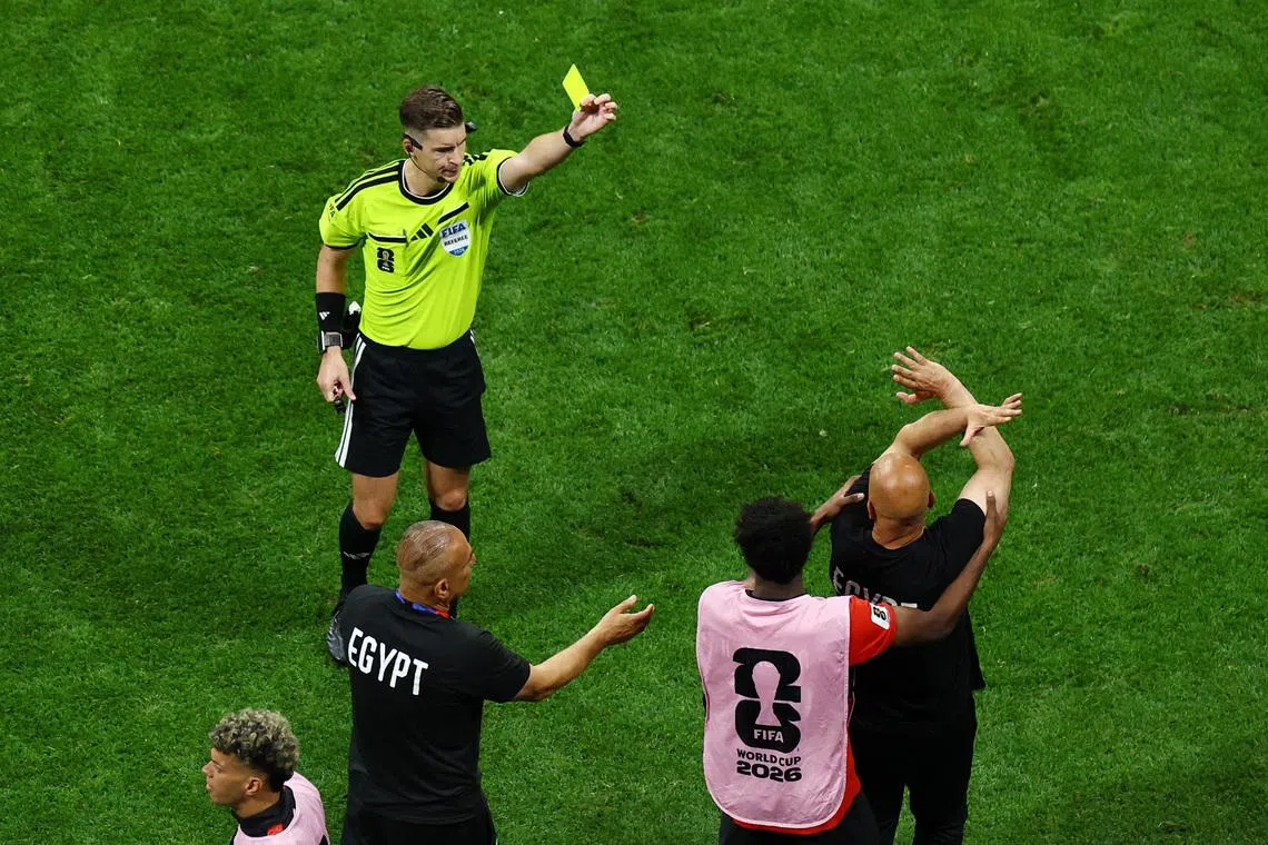 Soccer Football - FIFA World Cup 2026 - Round of 16 - Argentina v Egypt - Atlanta Stadium, Atlanta, Georgia, U.S. - July 7, 2026 Egypt coach Hossam Hassan is shown a yellow card by referee Francois Letexier as he makes anti-racism gesture  REUTERS/Marco Bello