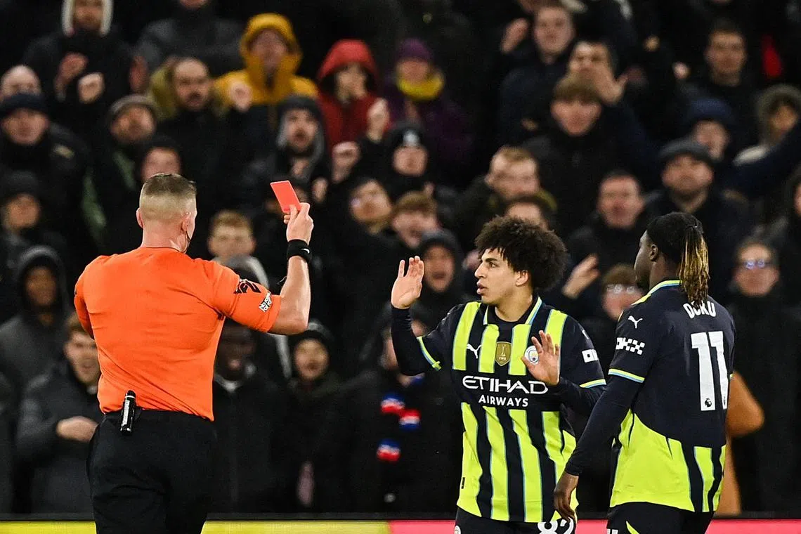 Manchester City's English defender #82 Rico Lewis (C) reacts as he receives a red card during the English Premier League football match between Crystal Palace and Manchester City at Selhurst Park in south London on December 7, 2024. (Photo by Glyn KIRK / AFP) / RESTRICTED TO EDITORIAL USE. No use with unauthorized audio, video, data, fixture lists, club/league logos or 'live' services. Online in-match use limited to 120 images. An additional 40 images may be used in extra time. No video emulation. Social media in-match use limited to 120 images. An additional 40 images may be used in extra time. No use in betting publications, games or single club/league/player publications. / 