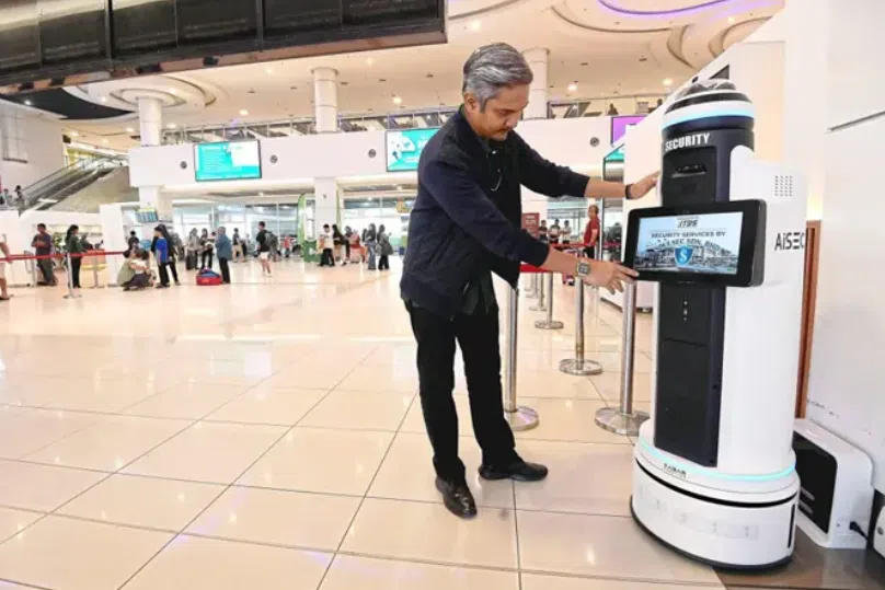 A TBS staff member prepping the security robot for official trial. 