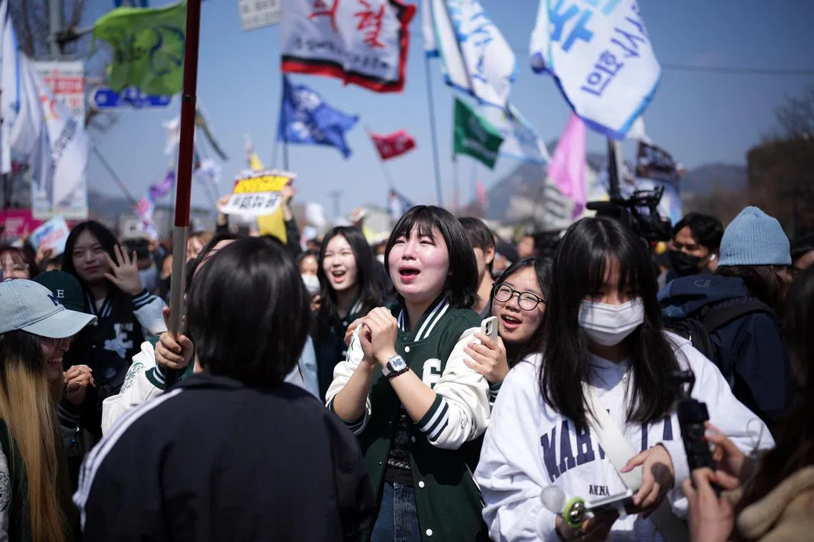 Students from Ewha Womans University cheer the Constitutional CourtÕs decision to remove the impeached President Yoon Suk Yeol in Seoul, South Korea, on Friday, April 4, 2025. The rise and fall of Yoon Suk Yeol exposed a vulnerability in South Korean democracy, but also a resilience. Its people were always ready to fight for it. (Jun Michael Park/The New York Times)
