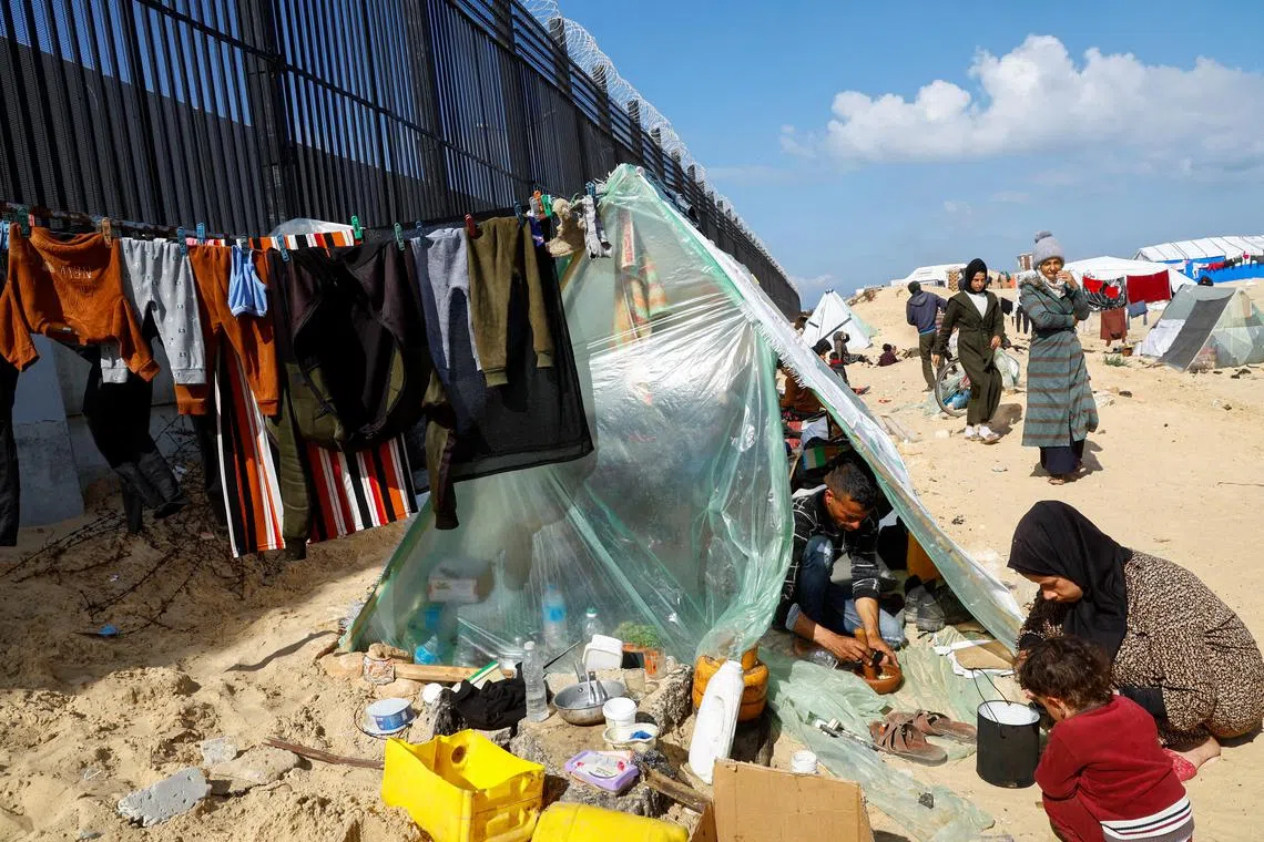 Displaced Palestinians prepare food as they shelter at the border with Egypt in Rafah in the southern Gaza Strip on Feb 10, 2024.