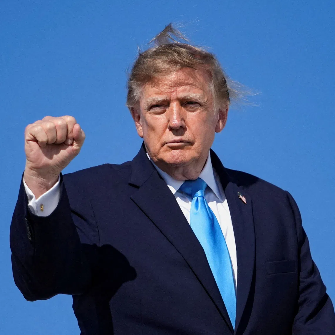 US President Donald Trump makes a fist as he boards Air Force One en route to Grand Island, Nebraska, at Joint Base Andrews, Maryland, US, on Oct 5.