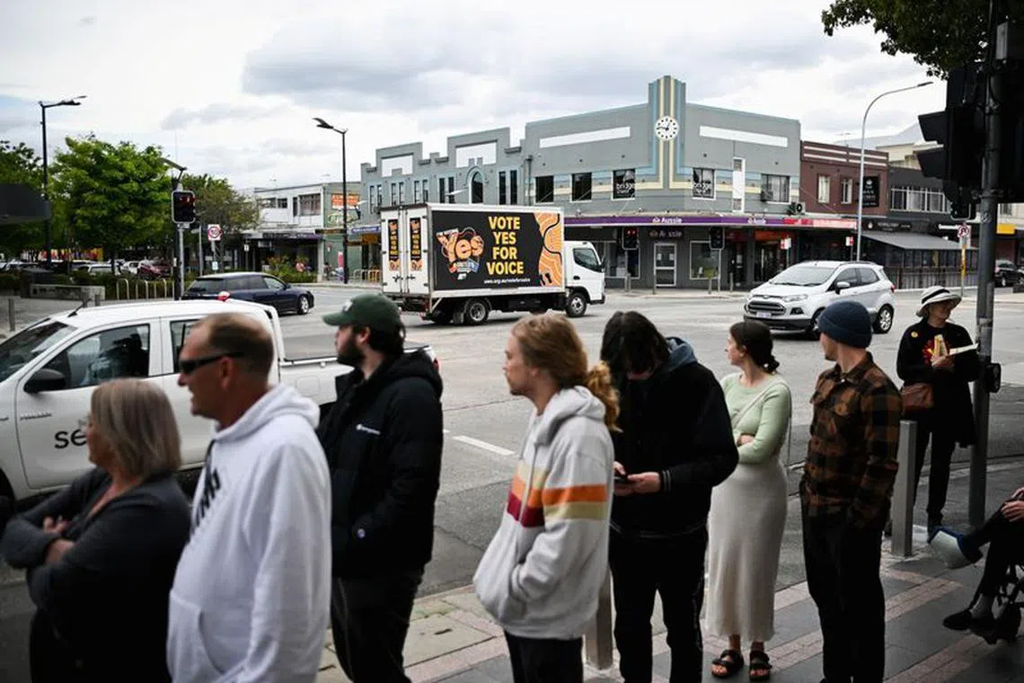 'Yes' campaigners drive past voters lining up at a polling booth during The Voice referendum in Queanbeyan, Australia, October 14, 2023. REUTERS/Tracey Nearmy