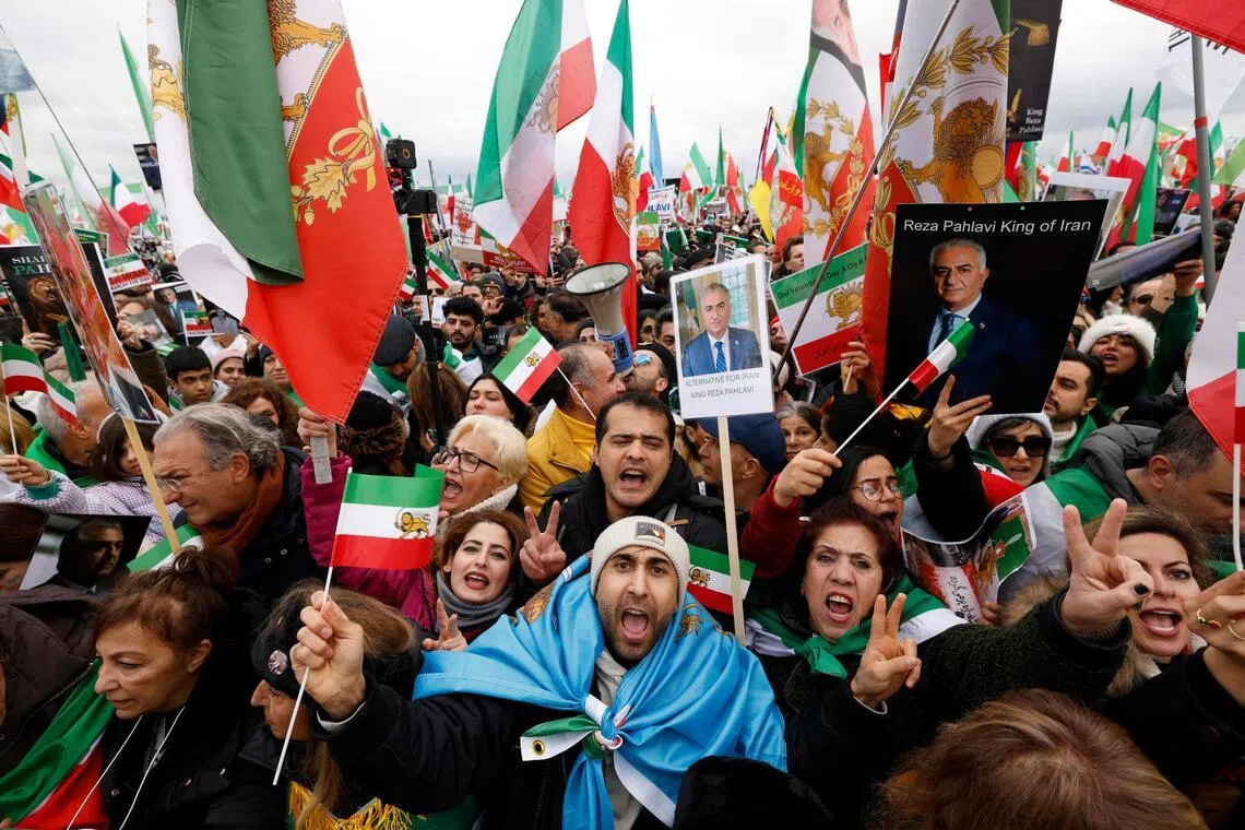 People protesting in Munich on Feb 14, holding the historic Iranian "Lion and Sun" national flag, as well as posters depicting Iran's former crown prince and now key opposition figure, Mr Reza Pahlavi.