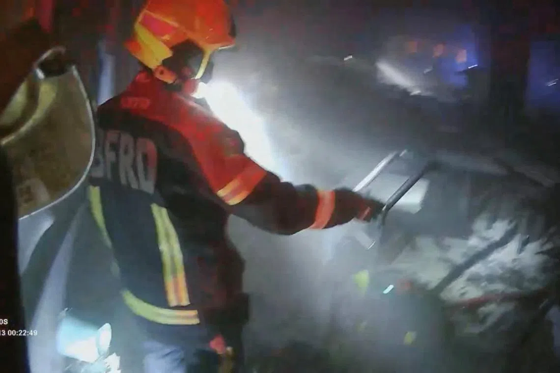 A rescue worker inspects the site of a deadly fire at a pub in Bangkok, Thailand, on July 13.
