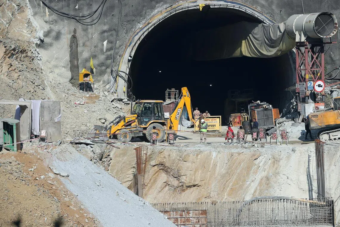Workers gather near the site of a tunnel collapse on the Brahmakal Yamunotri National Highway in Uttarkashi, India, Nov 25, 2023.  
