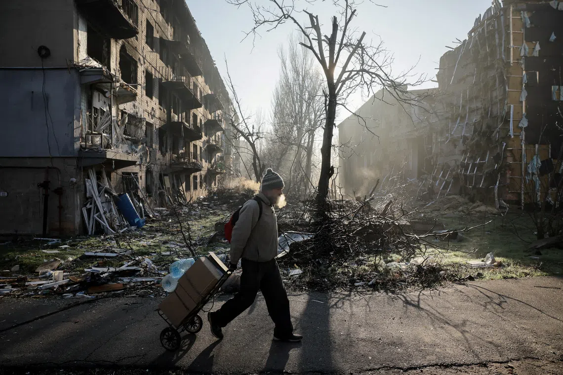 A resident walks near apartment buildings damaged by a Russian military strike, amid Russia's attack on Ukraine, in the frontline town of Kostiantynivka in Donetsk region, Ukraine November 15, 2025. Oleg Petrasiuk/Press Service of the 24th King Danylo Separate Mechanized Brigade of the Ukrainian Armed Forces/Handout via REUTERS ATTENTION EDITORS - THIS IMAGE HAS BEEN SUPPLIED BY A THIRD PARTY.      TPX IMAGES OF THE DAY