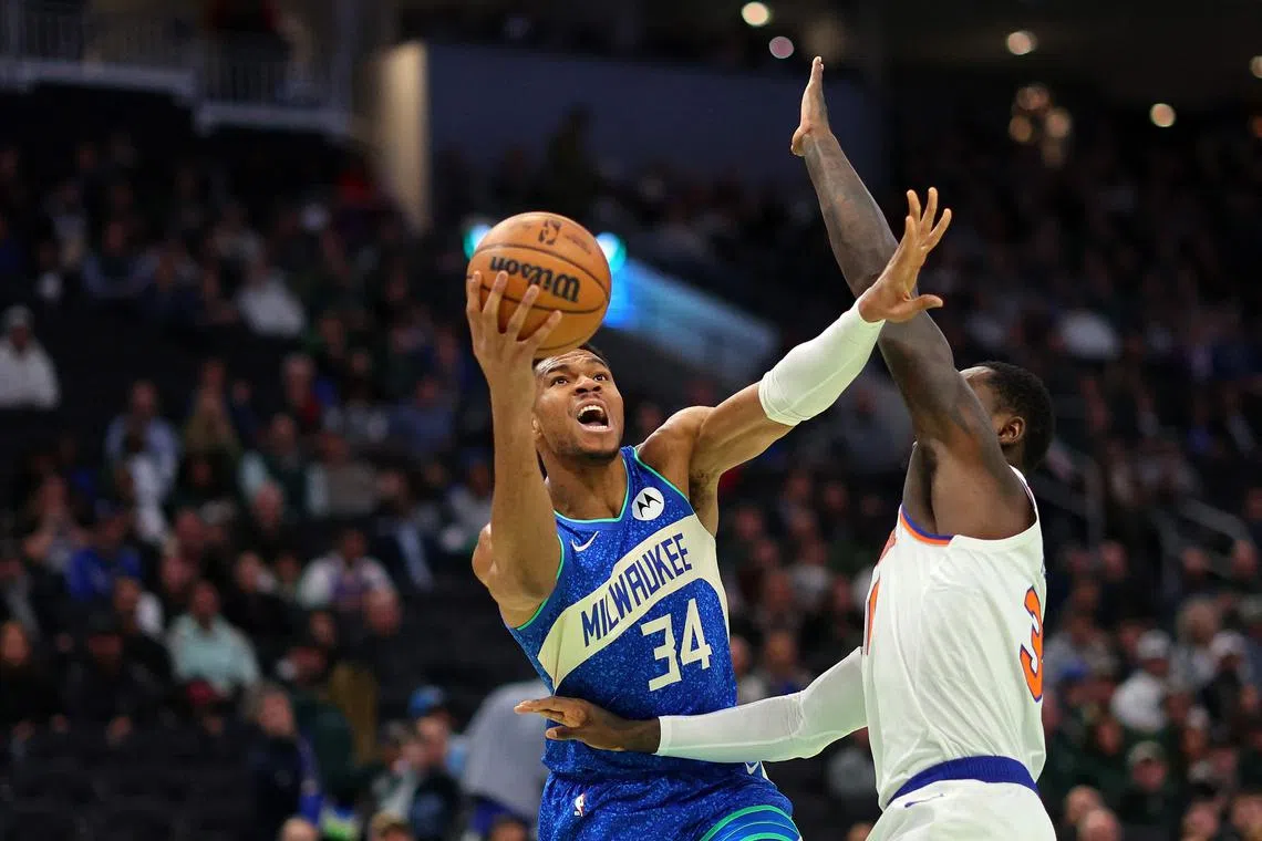 Giannis Antetokounmpo of the Milwaukee Bucks is defended by Julius Randle of the New York Knicks during the first half at Fiserv Forum.