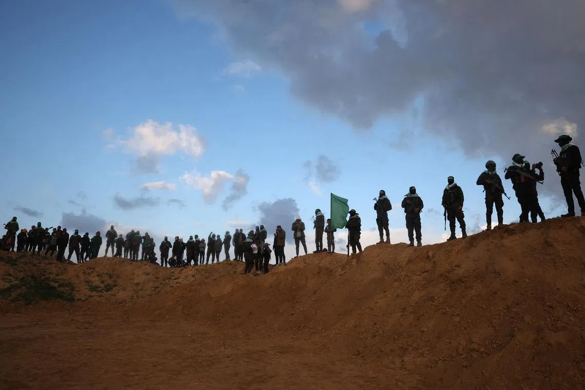 Palestinian militant group Hamas fighters standing at attention ahead of the handing over the bodies of four Israeli hostages in Khan Yunis in the southern Gaza, on Feb 20, 2025. 