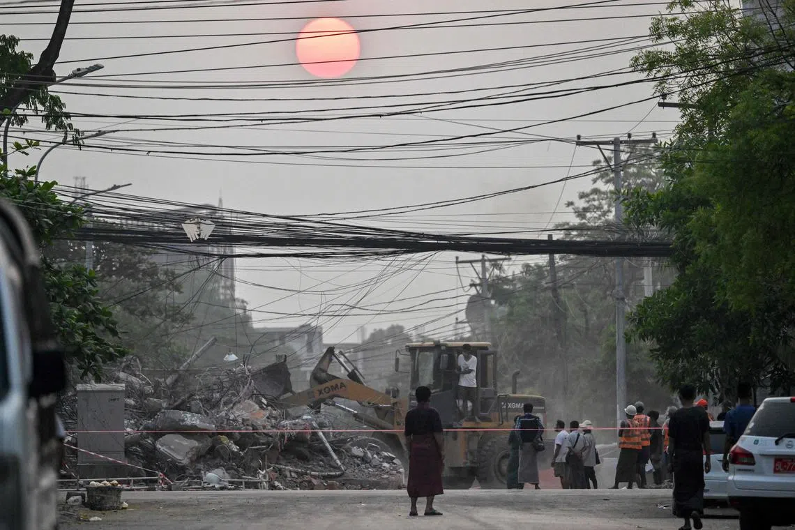 Heavy construction equipment is used to clear rubble from a collapsed building in Mandalay, Myanmar, on April 1.