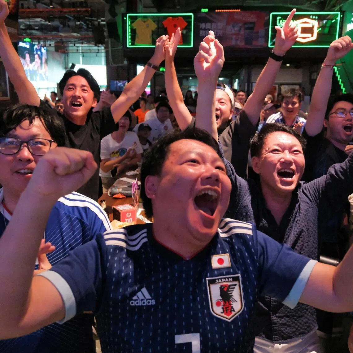 Football fans react during a FIFA World Cup match between Japan and Tunisia at a football watch party in Shanghai on June 21.