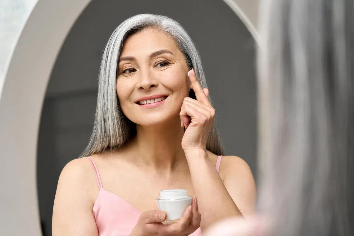 llmeno04 - Mature beautiful happy middle aged asian woman, older grey haired lady looking at mirror touching face applying whitening antiaging anti wrinkle perfect skin care cream.

Credit: ISTOCKPHOTO