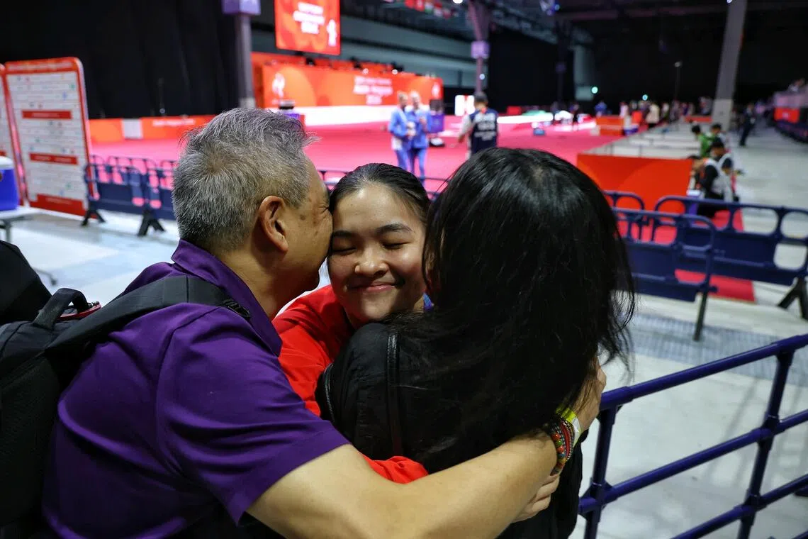 Bronze medallist Maxine Wong (centre) of Singapore getting a hug from her father Philip Wong and mother Chan Bee Bee after the medal ceremony for the women’s foil individual during the Asian Games.