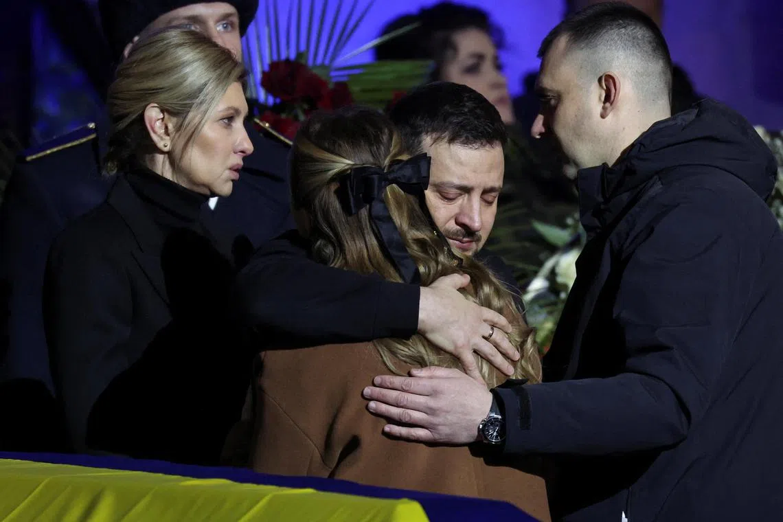 Ukraine's President Volodymyr Zelensky and first lady Olena Zelenska offer their condolences to relatives, at a memorial service for seven officials who died in a helicopter crash near Kyiv.