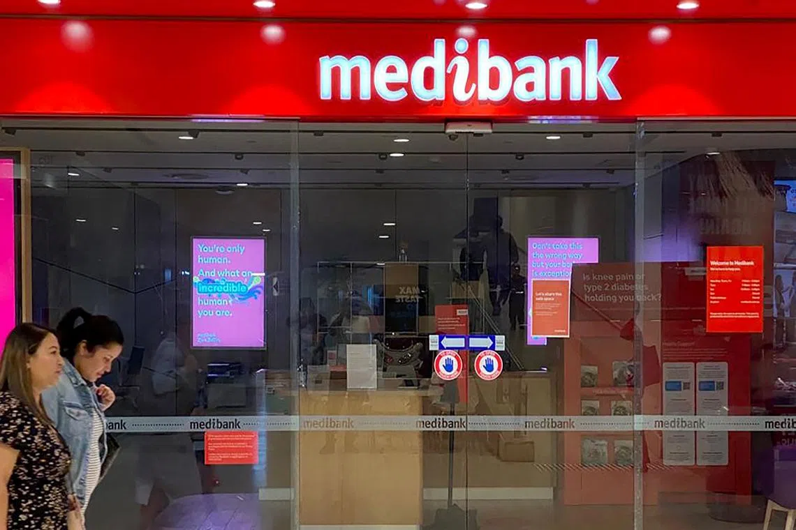 People walking past a shop front for Australia's largest health insurance company, Medibank, in Sydney on Nov 11, 2022.  Hackers carried out a cyberattack on Medibank that breached the data of 9.7 million people.