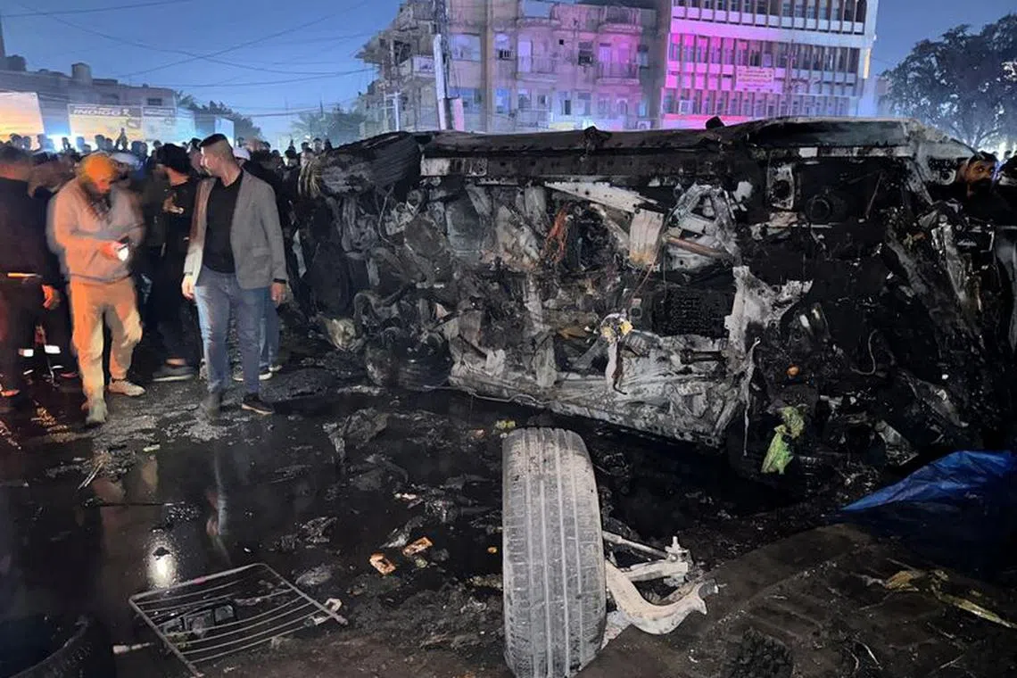 People inspect a vehicle, after what security sources said was a deadly drone strike, in Baghdad, Iraq, February 7, 2024. REUTERS/Ahmed Saad