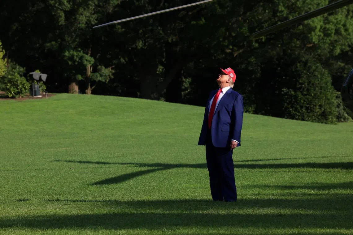 U.S. President Donald Trump looks up at the new flagpole as he arrives at the White House in Washington, D.C., U.S., June 21, 2025. REUTERS/Kevin Mohatt