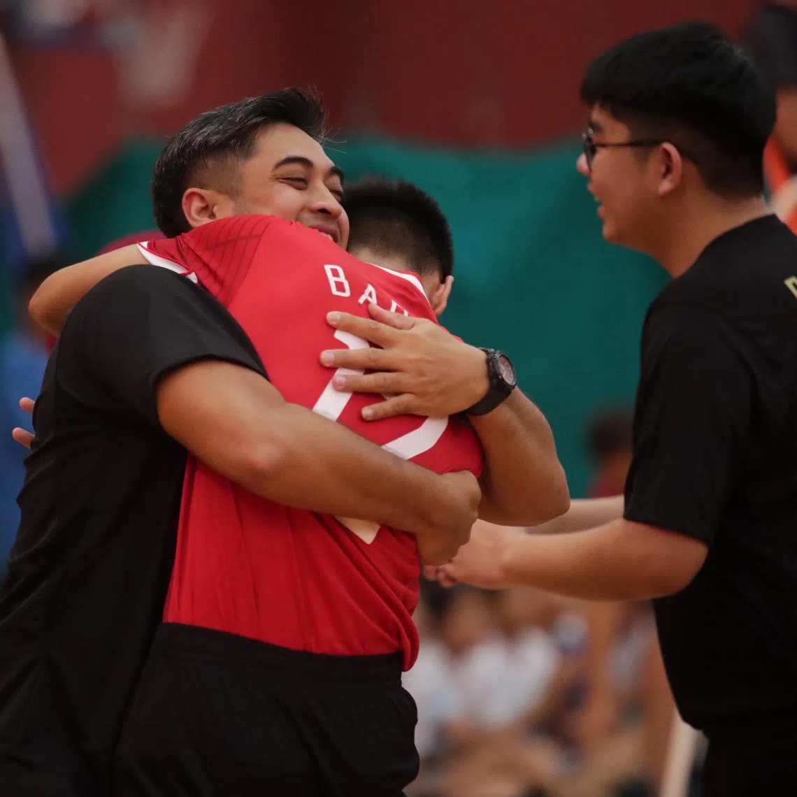 Muhammad Nor Aniq Mohamad Nazri (#12) hugs his coach, Rithwan Kassim, after Bartley Secondary School won the B Division Boys sepak takraw finals at the Ministry of Education’s (MOE) Physical, Sports and Outdoor Education Branch on Thursday. After losing the first regu, Bartley beat Woodlands by a score of 2-1.
