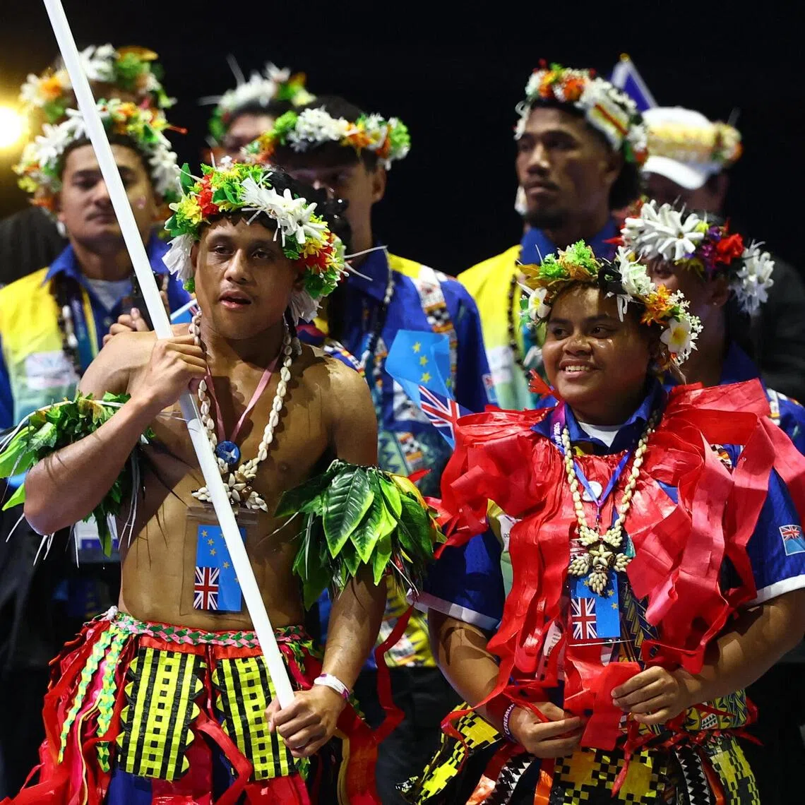 Flag bearers Tarona Taafaki (right) and Pasoni Taafaki lead athletes of Tuvalu during the Commonwealth Games opening ceremony.