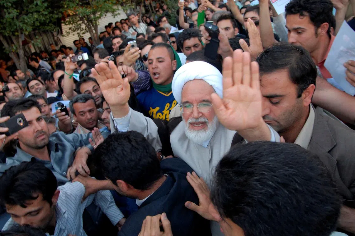 FILE PHOTO: Iran's presidential candidate Mehdi Karroubi (3rd R) joins a crowd of supporters in Tehran June 17, 2009. REUTERS/Demotix/File Photo