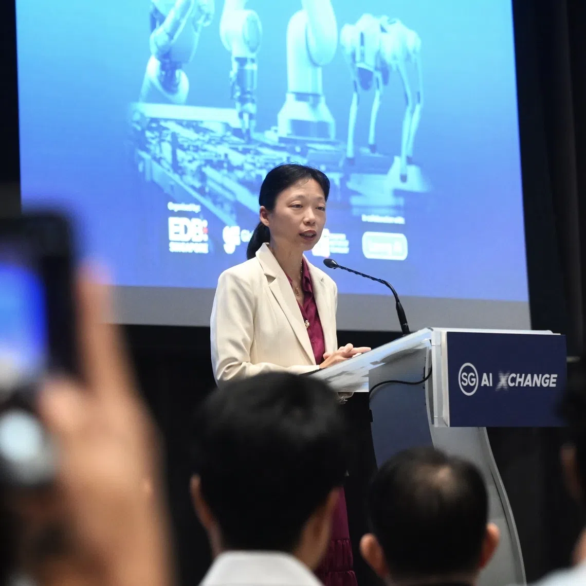 Acting Minister for Manpower Jasmin Lau speaking at the inaugural SG AI Xchange on Sept 17.