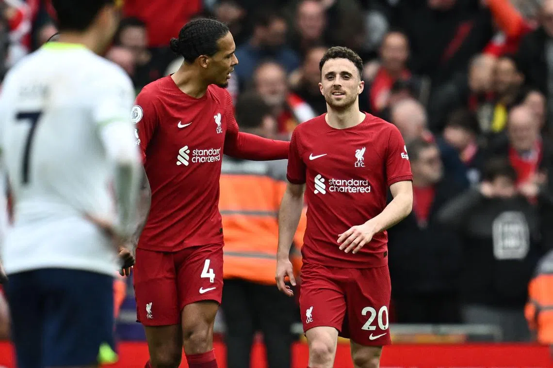 Striker Diogo Jota (right) is congratulated by teammate Virgil van Dijk, after scoring a late fourth goal for Liverpool.