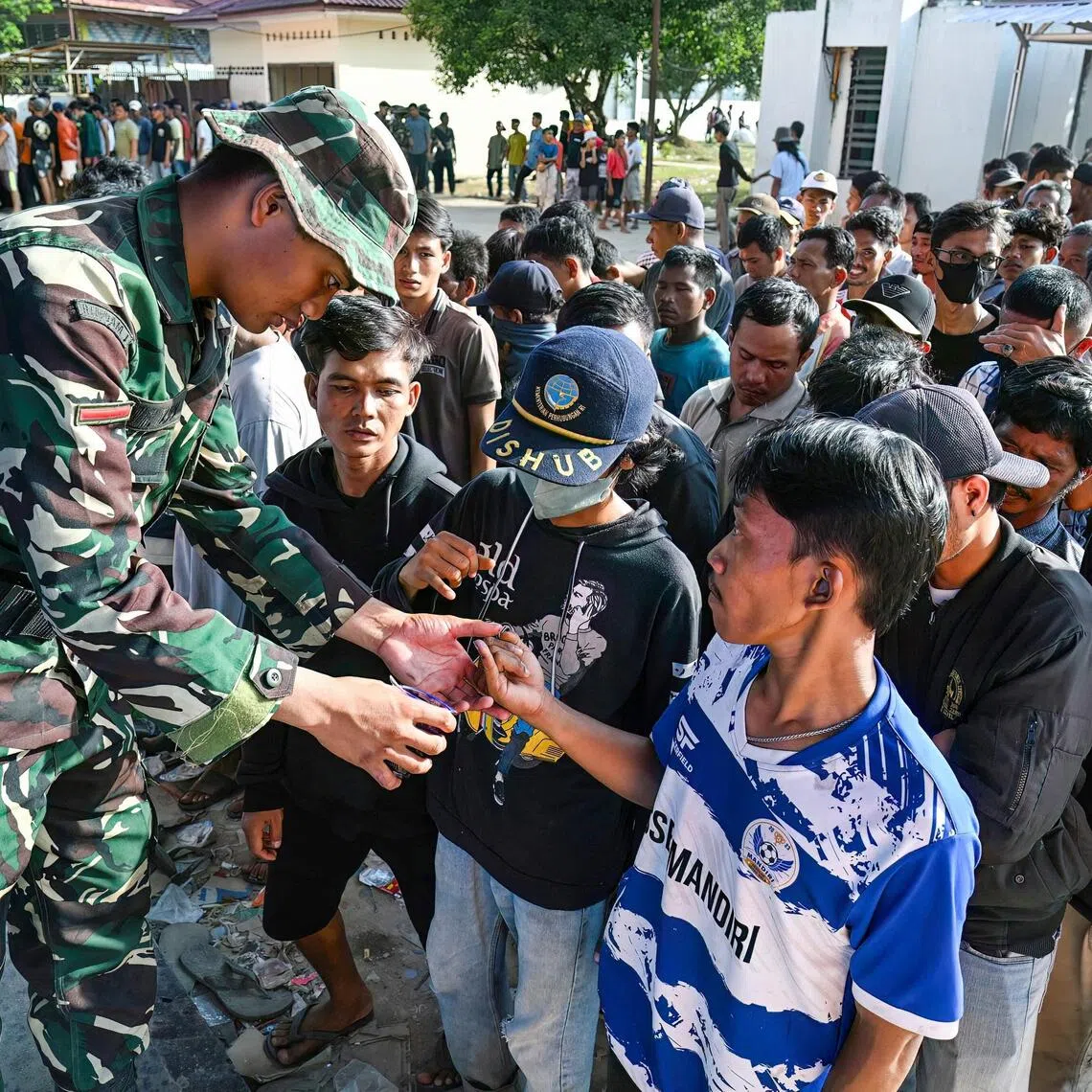 AFP saw the lucky recipients on Dec 3 have their fingers marked with ink to prevent double distribution and hoarding.
