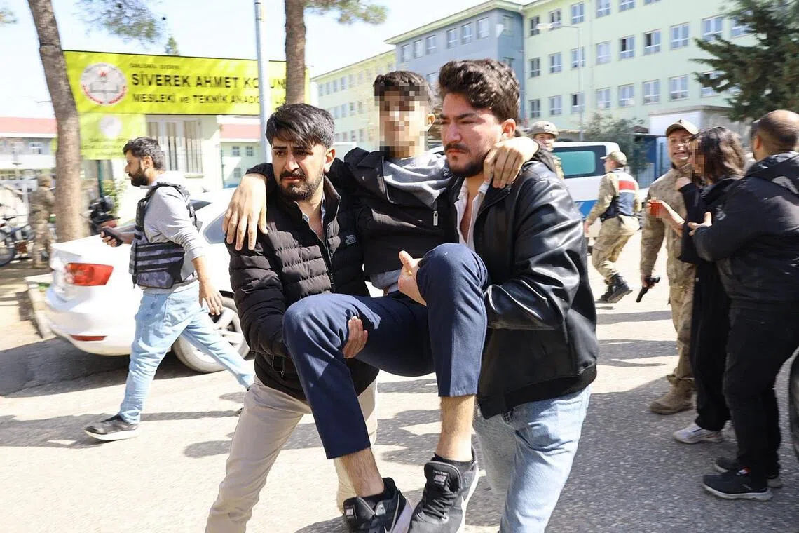 An injured student evacuated as special force security surround the school in south-eastern Turkey on April 14, 2026.