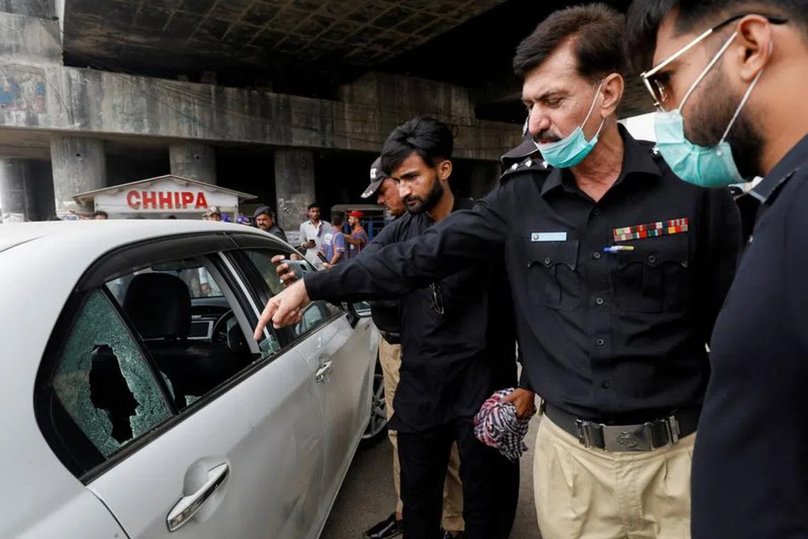 FILE PHOTO: A Pakistani police officer surveys the site after, according to police, gunmen on a motorcycle opened fire on a vehicle belonging to a Chinese national, along a road in Karachi, Pakistan July 28, 2021. REUTERS/Akhtar Soomro/File Photo