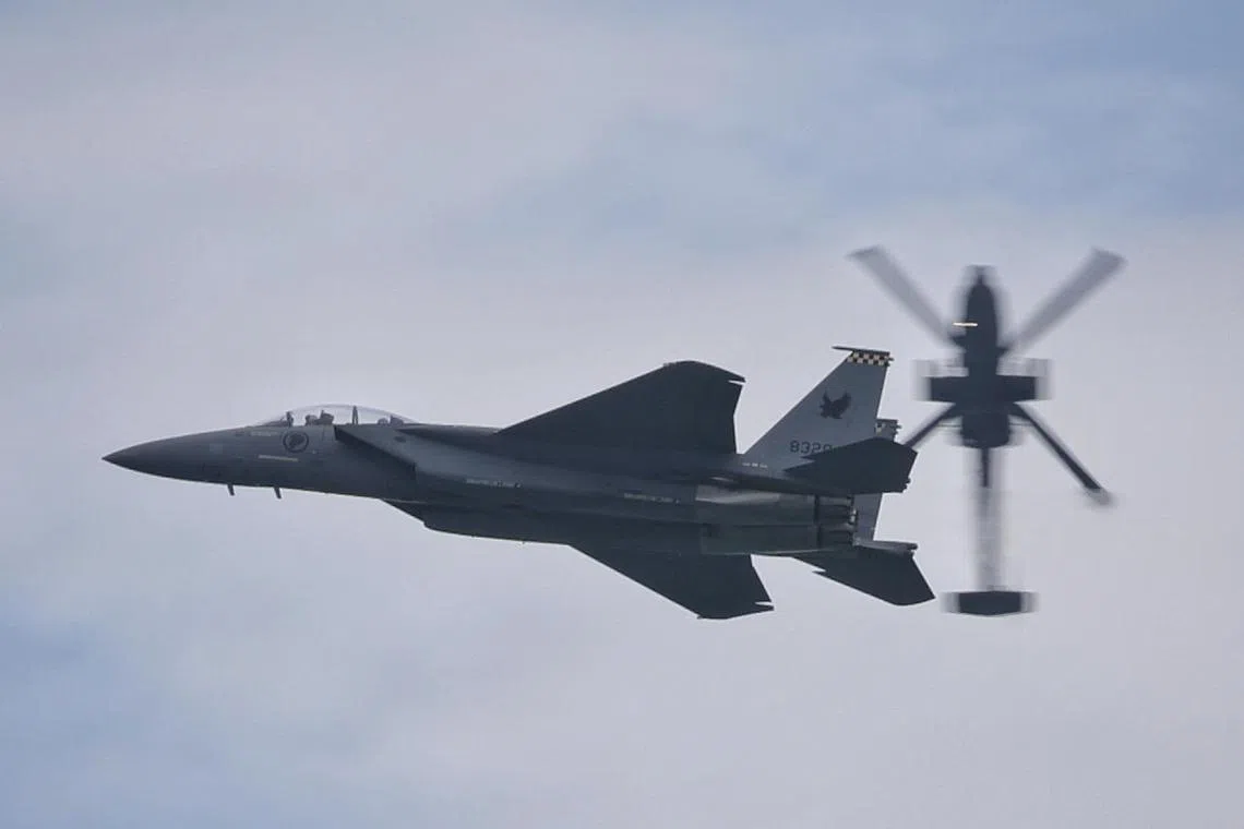 (EMBARGOED TILL 18 FEB 2024 6PM)
The Republic of Singapore Air Force’s (RSAF) F-15SG fighter jet and AH-64D helicopter performing a new integrated manoeuvre “Slingshot” during a media preview of Singapore Airshow 2024 (SA24) at Changi Exhibition Centre on Feb 17, 2024. ST PHOTO: KEVIN LIM elair17