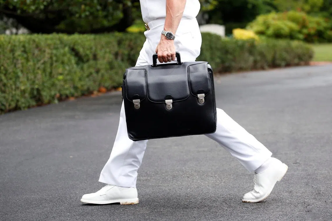 A military aide carries a briefcase containing launch codes for nuclear weapons at  the White House in Washington. REUTERS/Joshua Roberts