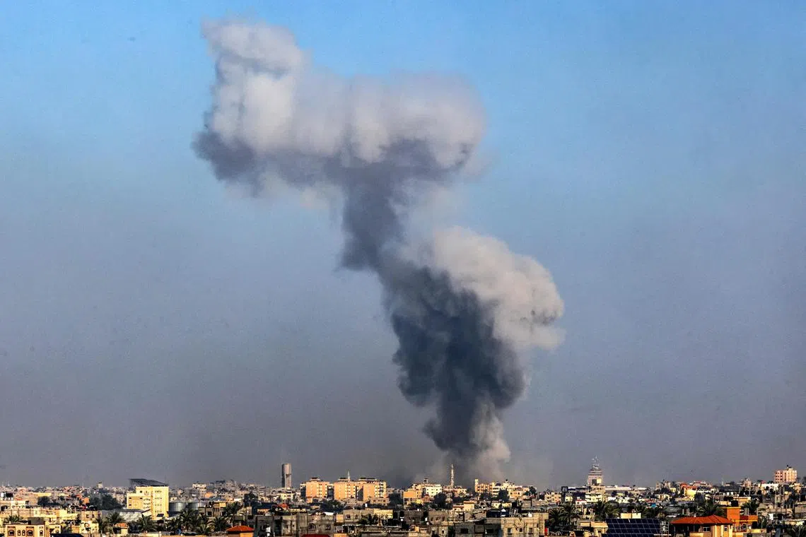 A picture taken from Rafah shows smoke billowing over Khan Younis, in the southern Gaza Strip, during Israeli bombardment in its ongoing war against Hamas.